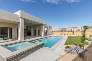 View of swimming pool featuring a patio, a mountain view, a fenced backyard, a ceiling fan, and a pool with connected hot tub