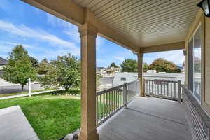 Wooden porch featuring a yard and a residential view