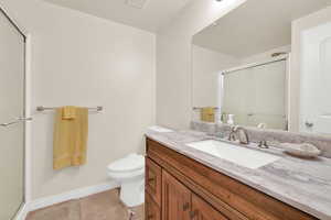 Bathroom featuring a stall shower, vanity, and light tile patterned flooring