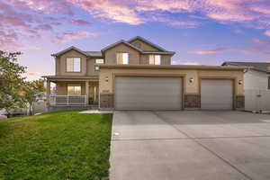 Traditional home featuring covered porch, stucco siding, driveway, a gate, and brick siding