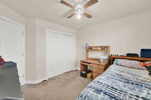 Bedroom featuring light colored carpet, a closet, and ceiling fan