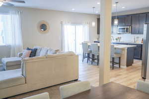 Living room with light wood-type flooring and recessed lighting
