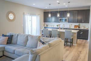 Living area with recessed lighting and light wood-style flooring
