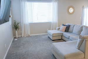Carpeted living room featuring baseboards
