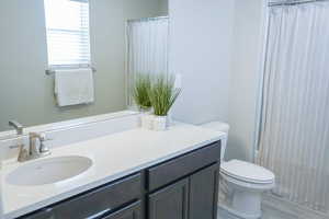 Bathroom with vanity, shower / bath combo with shower curtain, and wood finished floors