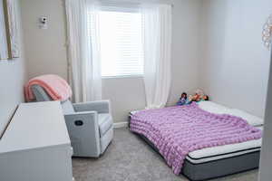 Bedroom featuring carpet flooring and baseboards