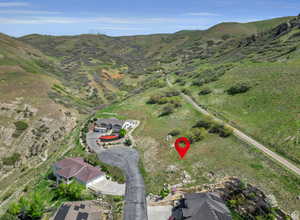 Aerial view of property and surrounding area featuring a mountainous background