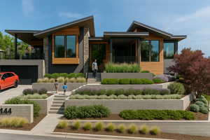 Modern home with a garage, stone siding, and driveway