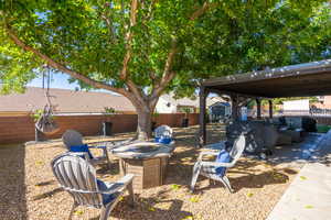 Fenced backyard featuring a storage unit, a patio, and an outdoor living space with a fire pit