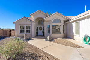 Entrance to property featuring a tile roof and stucco siding