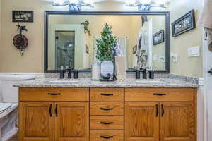 Full bathroom featuring double vanity, a shower stall, and a chandelier