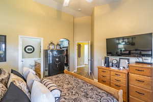 Bedroom with a spacious closet, a high ceiling, ceiling fan, and ensuite bath