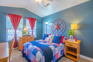 Bedroom with vaulted ceiling, light carpet, and ceiling fan