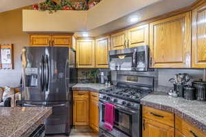 Kitchen with tile countertops, stainless steel appliances, and brown cabinets