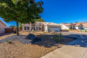 View of front of property featuring driveway, a garage, and stucco siding