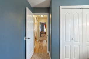 Corridor featuring arched walkways and light carpet
