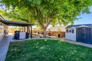 Fenced backyard with a shed and a patio