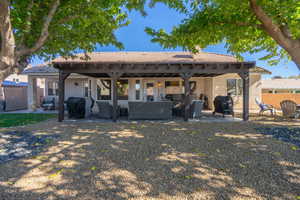 Back of house featuring a patio area, stucco siding, and an outdoor living space
