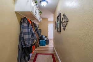 Corridor with a textured wall and wood finished floors
