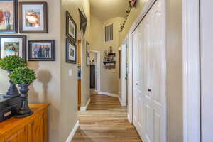 Hallway featuring light wood-type flooring and a textured ceiling