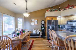 Dining room featuring light wood-style floors and lofted ceiling