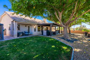 Rear view of property with an outdoor living space, a chimney, a patio area, and stucco siding