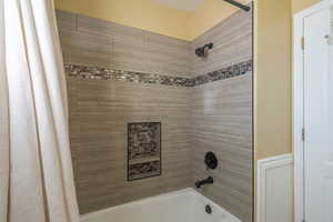 Bathroom featuring shower / bath combination with curtain