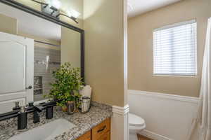Full bath with vanity, wainscoting, and a shower with curtain