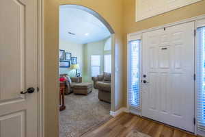 Entryway with arched walkways and wood finished floors