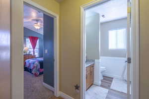 Bathroom with vanity, connected bathroom, a textured ceiling, light wood-style floors, and ceiling fan