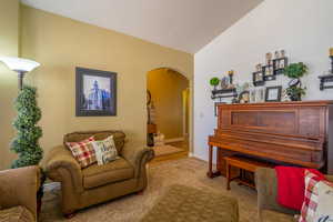 Sitting room featuring arched walkways and lofted ceiling