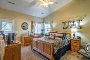 Bedroom featuring lofted ceiling, light carpet, and a ceiling fan