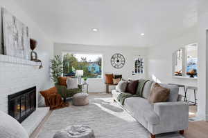Living room featuring wood finished floors, a fireplace, and recessed lighting