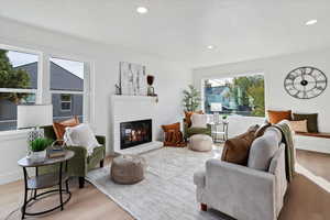 Living room featuring wood finished floors, recessed lighting, and a brick fireplace