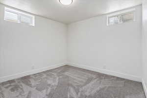 Below grade area with a textured ceiling and carpet floors