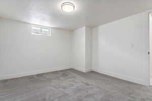 Empty room with carpet floors and a textured ceiling