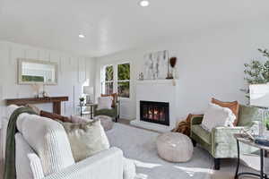Living room with a brick fireplace, wood finished floors, and recessed lighting