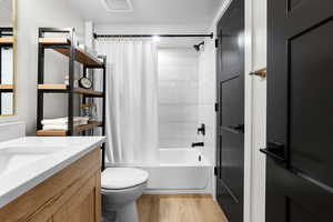 Bathroom with shower / tub combo, light wood-type flooring, and vanity