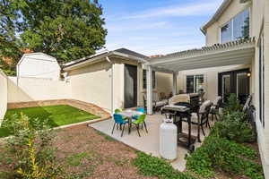 Fenced backyard with a patio and area for grilling