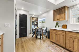 Dining room with light wood-style flooring and recessed lighting