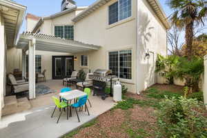 Back of property with stucco siding, a patio area, and a pergola