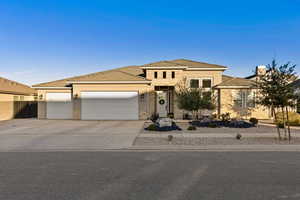 View of front facade with concrete driveway, an attached garage, stone siding, and a tile roof