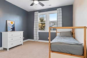 Bedroom with light carpet and a ceiling fan