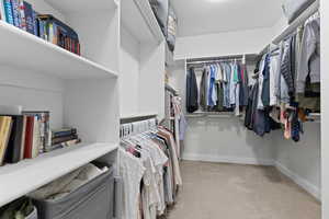 Spacious closet with light carpet