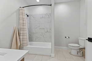 Bathroom featuring shower / bathtub combination with curtain, light tile patterned floors, and vanity