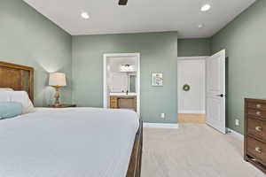 Bedroom with light carpet, recessed lighting, a ceiling fan, and ensuite bath