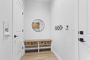 Mudroom with light wood-style floors and baseboards