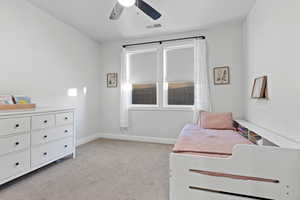 Bedroom with light colored carpet and ceiling fan