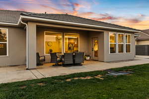 Back of house with a patio, stucco siding, and a tile roof