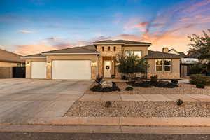 Mediterranean style home with stucco and stone exterior, 3 car garage, and concrete driveway.